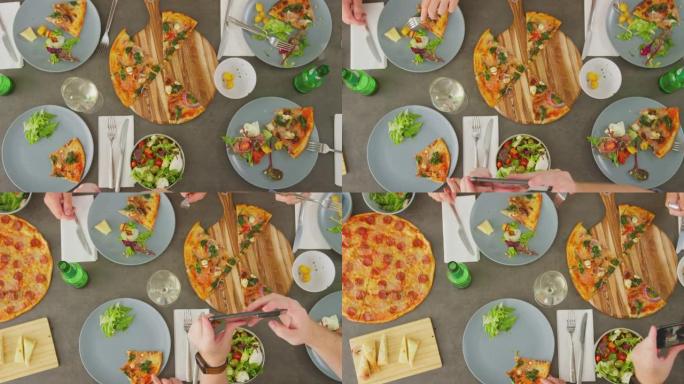 在意大利餐厅的朋友一起吃披萨并在手机上拍摄食物的俯视图-慢动作拍摄