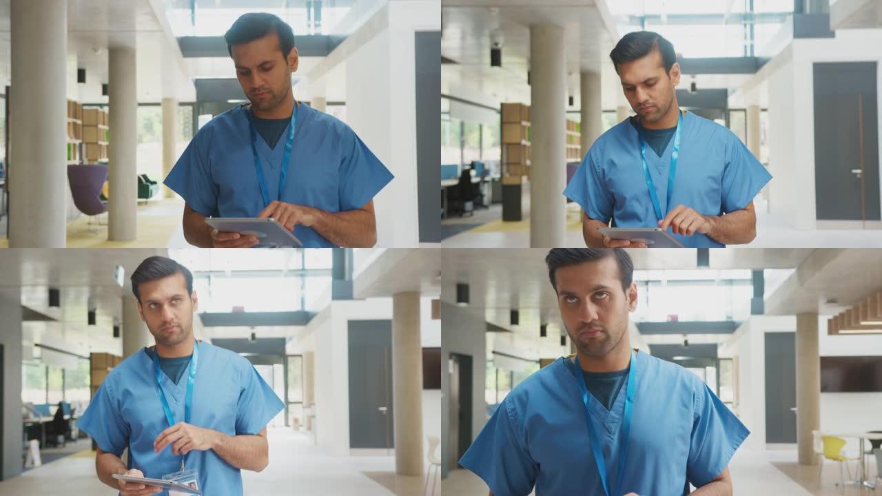 使用数字平板电脑在繁忙的医院大楼中穿行的磨砂膏中的男医生