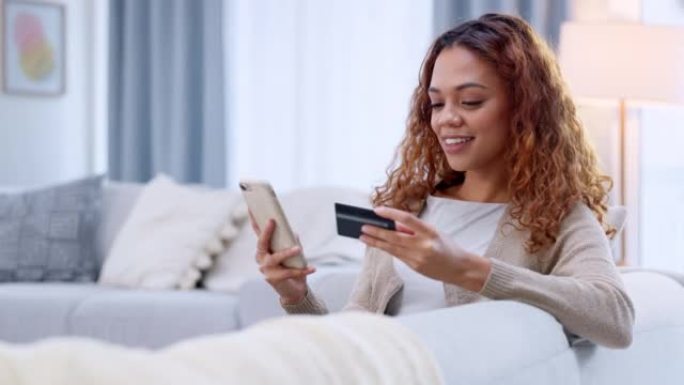 幸福的女人在家用信用卡在手机上进行数字购物。年轻快乐购物狂通过在线购物订购产品，并选择安全的即时银行