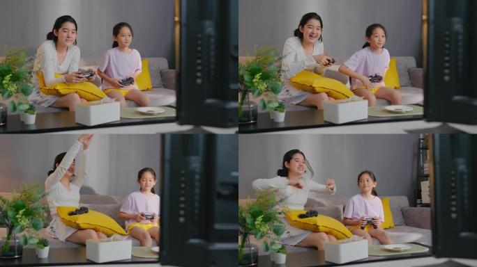 两个亚洲兄弟姐妹少年女孩在与兄弟在家里玩游戏机时击败姐妹