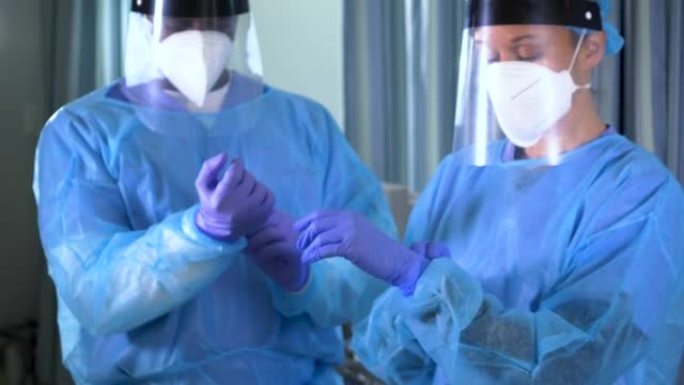 两名多种族的医护人员穿上完整的PPE