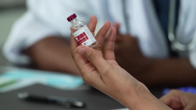 医疗专业人员与一小瓶新型冠状病毒肺炎疫苗