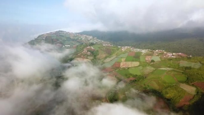 空中拍摄的山上有云和天空的小村庄
