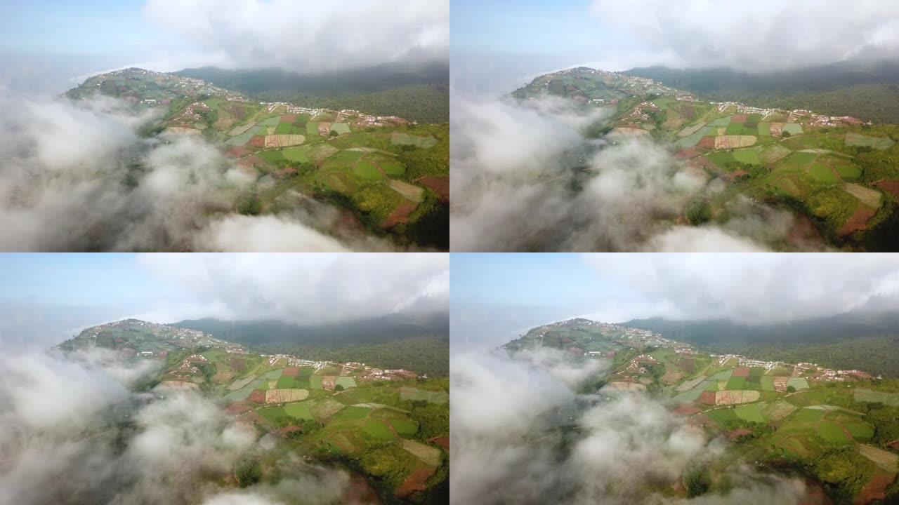 空中拍摄的山上有云和天空的小村庄