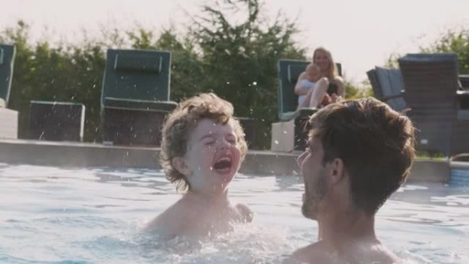 带着儿子和小女儿的家庭在暑假玩得开心，在室外游泳池里嬉戏