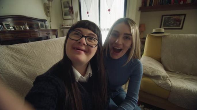 快乐的妹妹和十几岁的女孩的电影镜头，让技术视频一起在家给朋友或家人打电话。对话的概念，残障，残障，媒