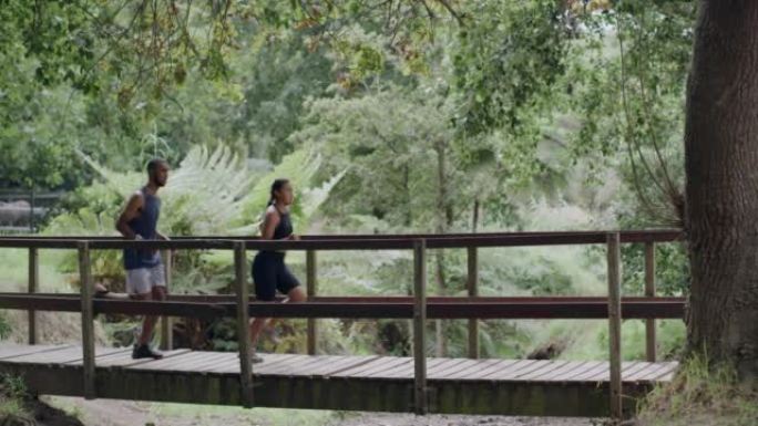 两名运动员在公园的行人天桥上奔跑。运动的年轻男女参加有氧运动。健身夫妇在户外比赛，让一起锻炼变得有趣