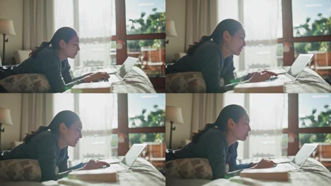 亚洲妇女在家中床上使用笔记本电脑