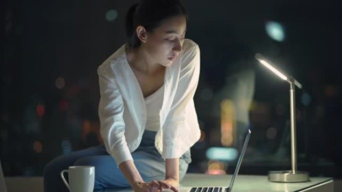 亚洲年轻女商人在夜间使用笔记本电脑工作