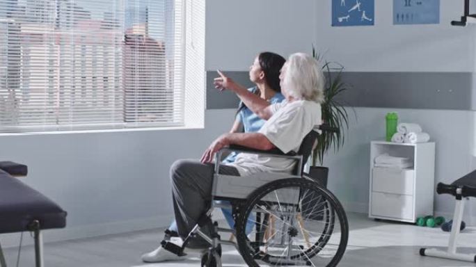 友好的康复治疗师与残疾老年患者交谈