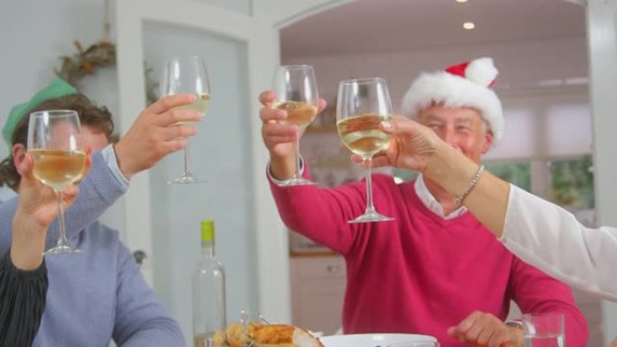 当多代家庭一起吃圣诞大餐时，成年人用酒烤面包
