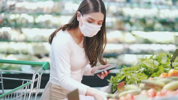 戴口罩的女人在超市选择蔬菜
