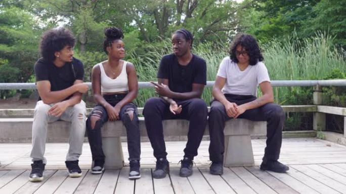跨种族的朋友在公园的长凳上闲逛