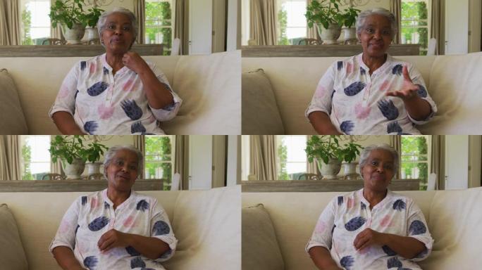 非裔美国高级妇女在家中看着相机说话的肖像
