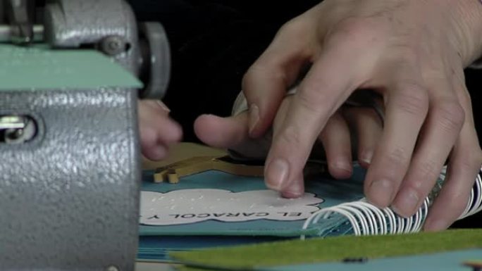在阿根廷一所盲人学校的教室里，一个孩子和一个成年人的手在阅读带有 “蜗牛” (西班牙语: “El C