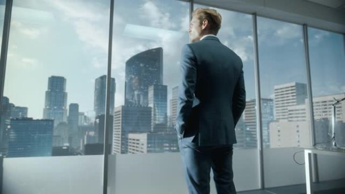 自信的年轻商人穿着一套完美的西装，站在他现代的办公室里，看着窗外的摩天大楼。成功的财务经理计划项目策