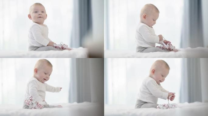 一个可爱的男婴在家里的床上玩玩具的4k视频片段