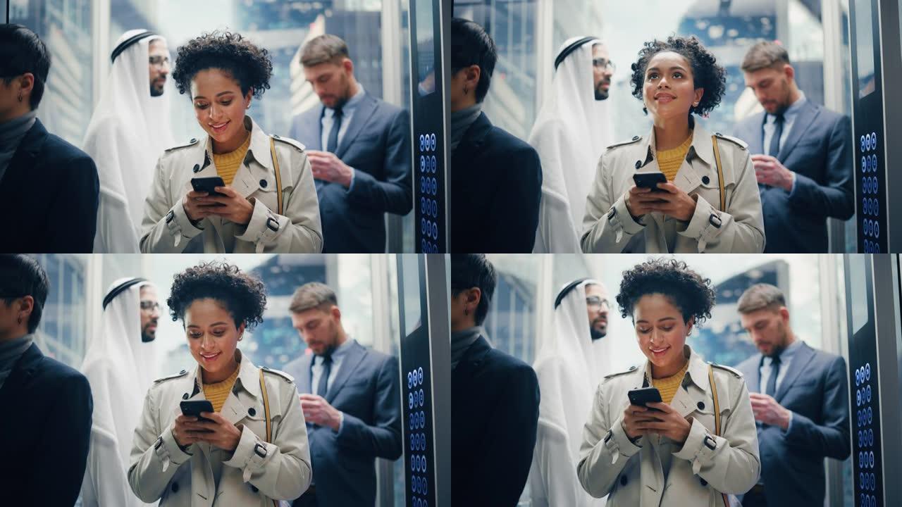四个不同的多民族国际人士乘坐玻璃电梯在现代商务中心办公。专注于年轻时尚的黑人拉丁女商人在电梯中使用智