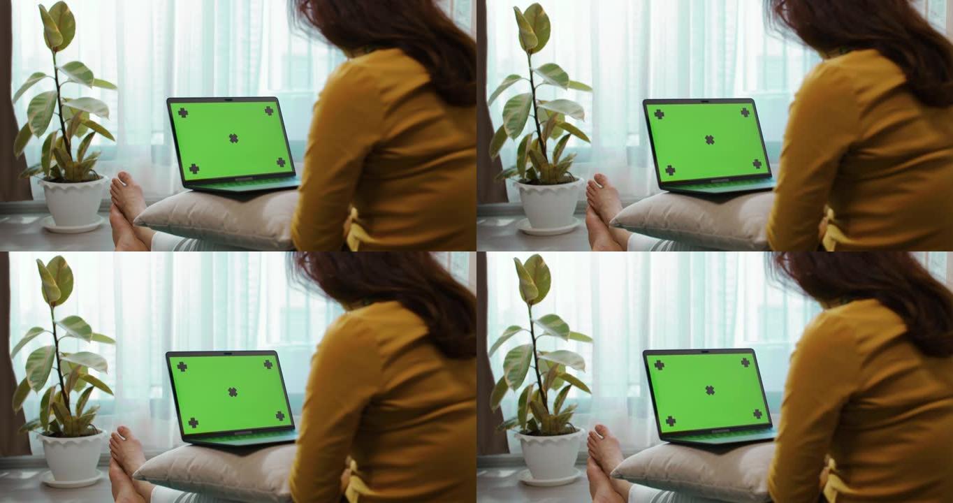 女性坐在地板上使用笔记本电脑绿屏