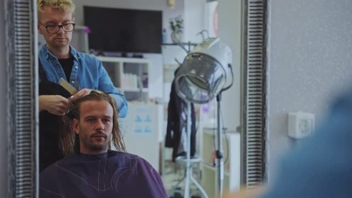 发型师在美容院为男性顾客梳理头发