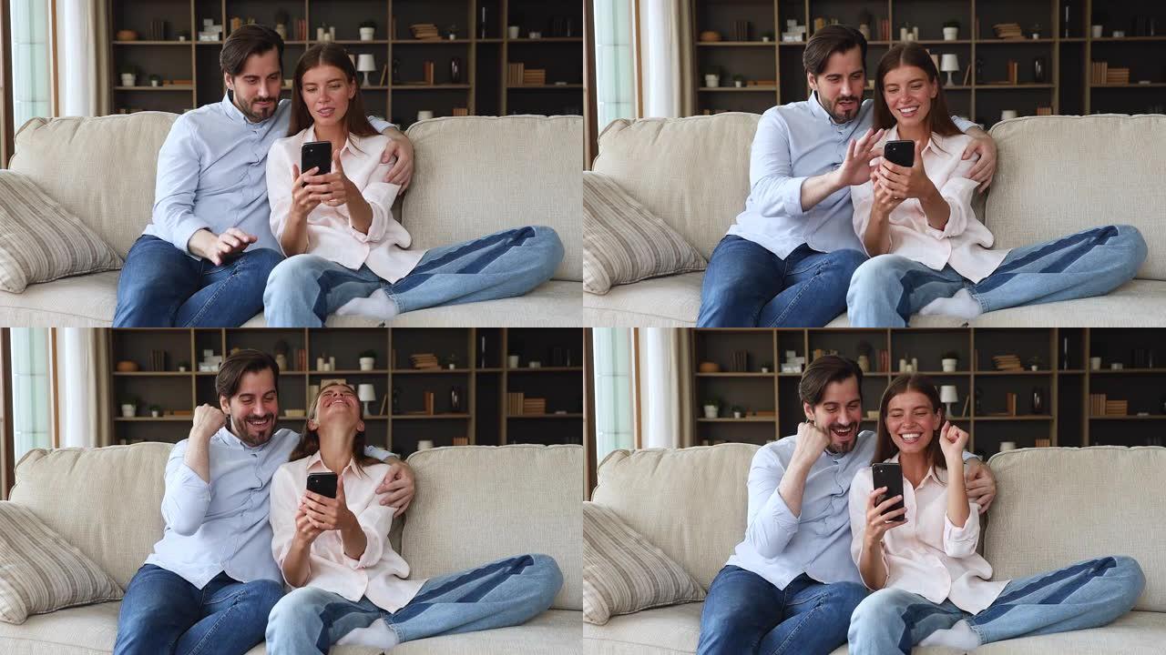 年轻夫妇在智能手机上阅读好消息感到喜出望外