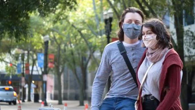 夫妇在城市街道上见面，戴着口罩