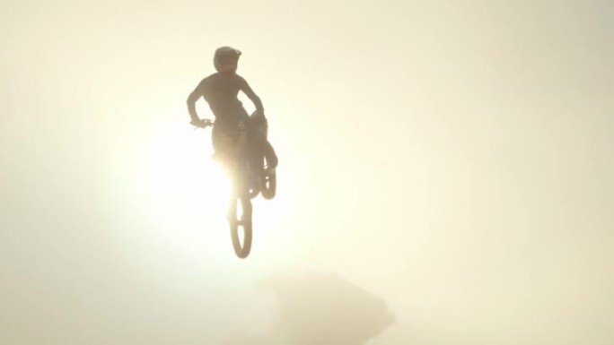 极限运动，摩托车或土车骑手在晴朗的晴天高速跳山。骑摩托车的人在崎rough的地形上跳摩托车比赛