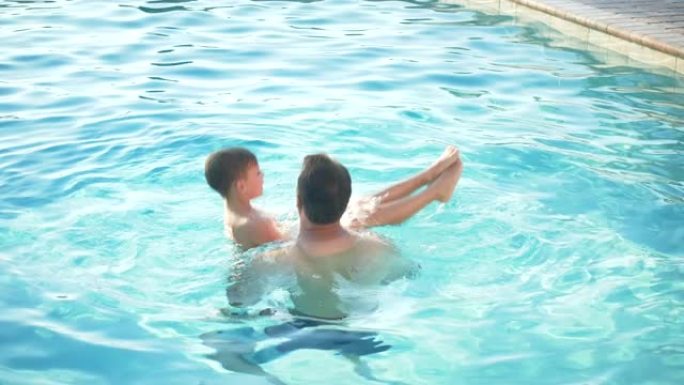 父亲和儿子在游泳池里玩耍