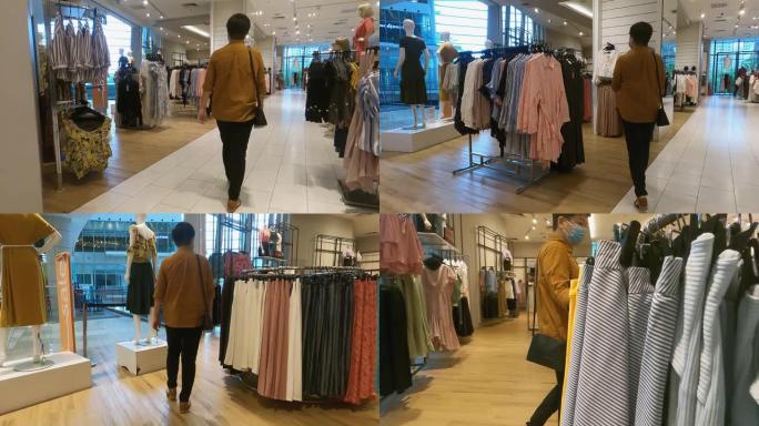 亚洲华裔女性在服装店购物，用口罩买衣服