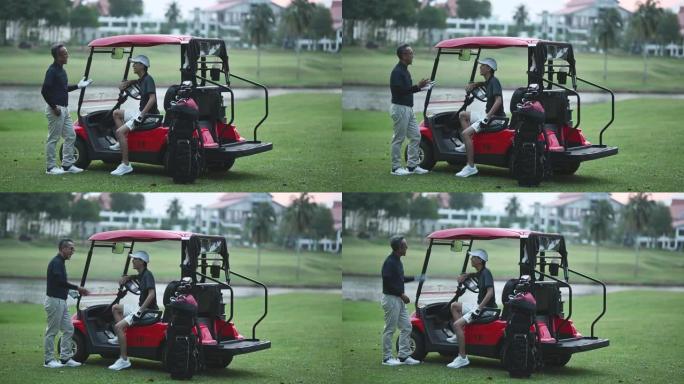一名亚洲华裔资深男子高尔夫球手赛后在高尔夫球场上与儿子交谈