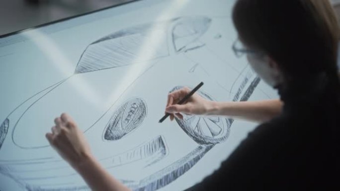 女性汽车设计师使用数字平板电脑用手写笔绘制原型汽车草图。在车辆生产工厂的研发工作室工作的有才华的工业