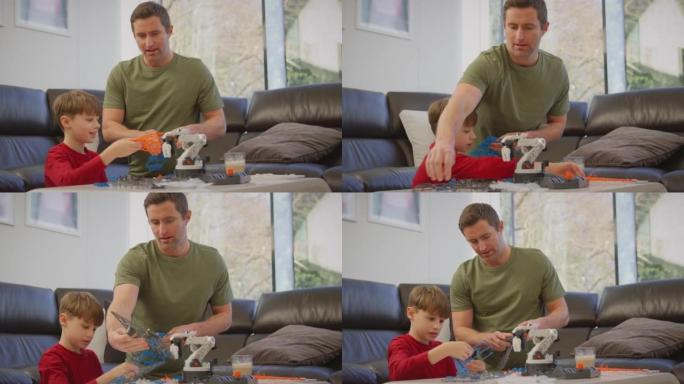 父亲和儿子穿着睡衣用塑料套件在家中建造机械臂，用于科学项目-慢动作拍摄