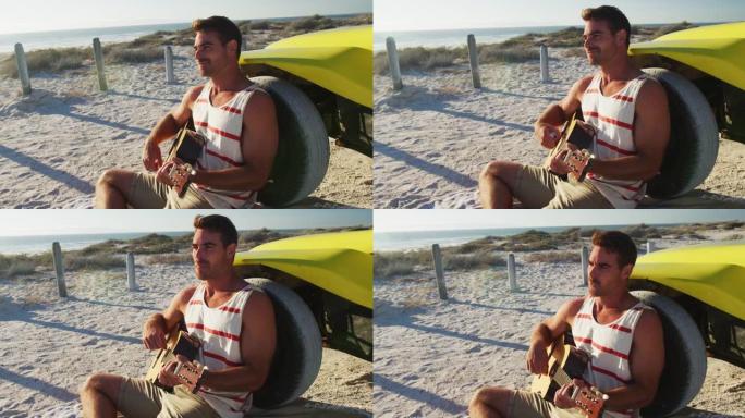 快乐的高加索人坐在海边的沙滩车旁边弹吉他