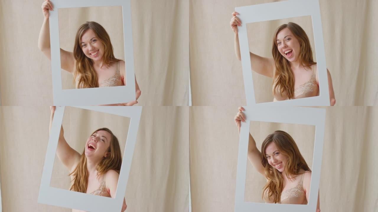 工作室拍摄的自信而积极的女人，假肢透过纸板相框拉着有趣的脸 -- 慢动作拍摄
