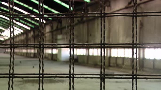 旧监狱走廊生锈的金属栅栏上的蜘蛛网。特写。4k分辨率。