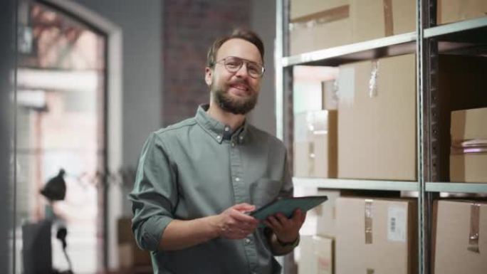 一个成功的小企业主使用平板电脑检查库存的肖像。留着小胡子的英俊男子摆姿势拍照，在仓库储藏室里微笑着，