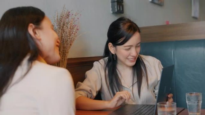 成功的亚洲女性创业经理和同事在餐厅一起工作。