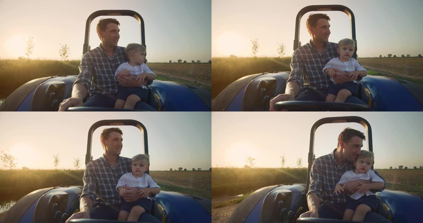 快乐农民父亲的真实镜头正和他的小儿子开着拖拉机，在阳光明媚的日子里展示了家庭农业财产。概念: 农业、