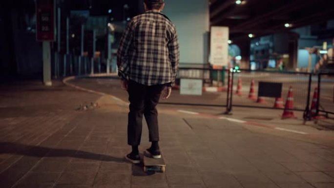 年轻人晚上在城市街道上滑板