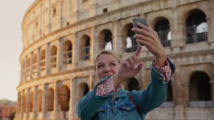 SLO MO女游客使用智能手机在罗马的罗马斗兽场自拍