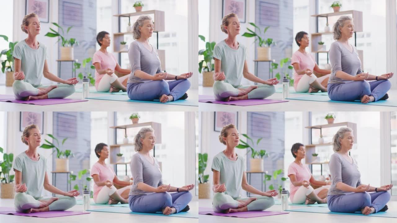 在瑜伽馆的健身课上，用手印手势冥想莲花姿势的成熟女性。平静、放松和专注的女士们坐着安静地祈祷内心的平
