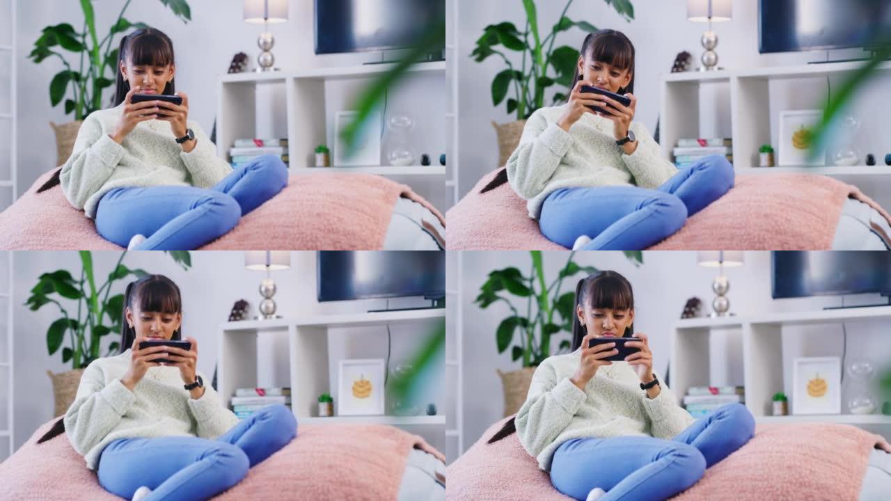 青少年在家里客厅的豆袋上放松时使用电话。周末玩手机游戏或流媒体视频的年轻女孩。在互联网或社交媒体上享