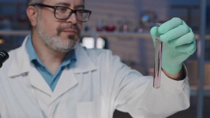 经验丰富的化学家，穿着实验室外套和手套，在烧瓶中研究液体