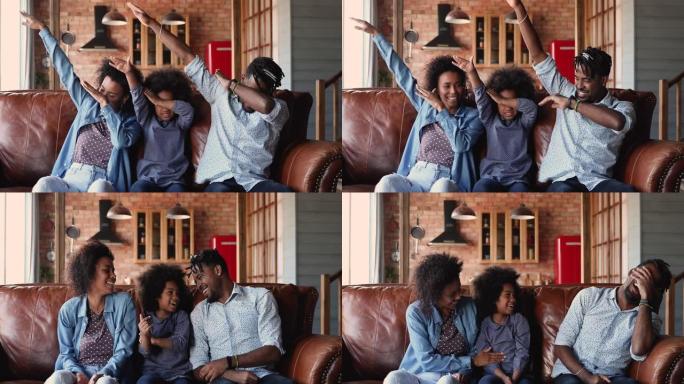 快乐的非洲家庭轻拍坐在家里的沙发上