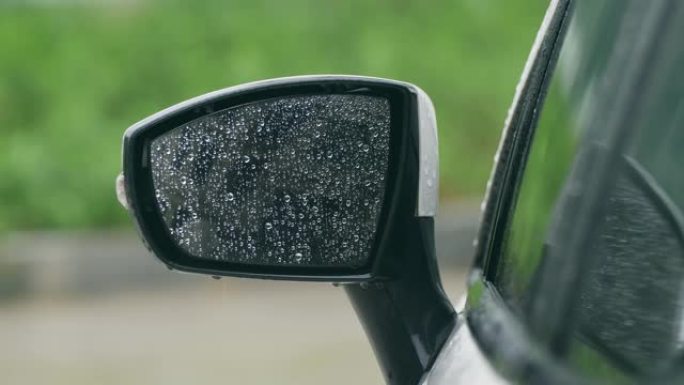 雨水落在汽车的镜子上