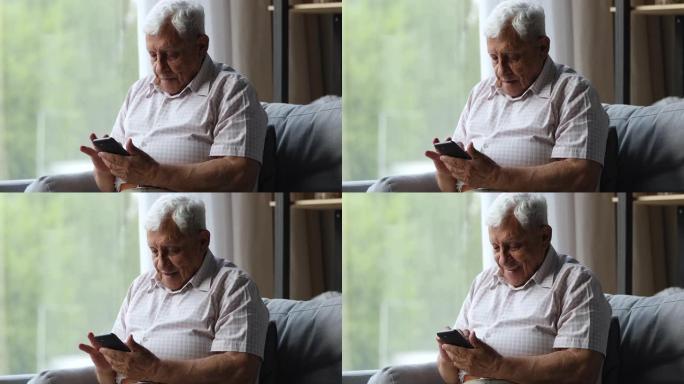 70年代的老人坐在沙发上，使用现代智能手机
