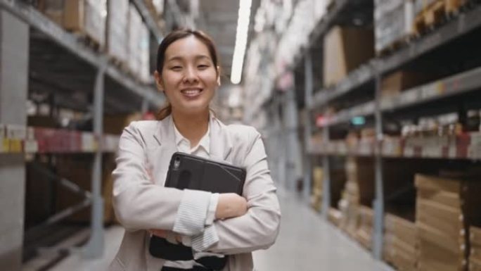 亚洲女商人站在数码平板电脑上的架子前，微笑着看着相机