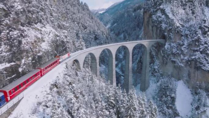 兰德瓦瑟高架桥与冰川和贝尔尼纳快车在瑞士下雪的冬天。