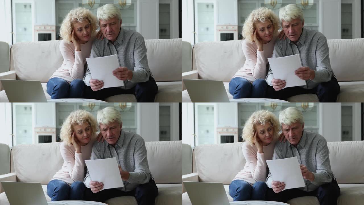 成熟的退休夫妇阅读文件表，保险，医疗协议