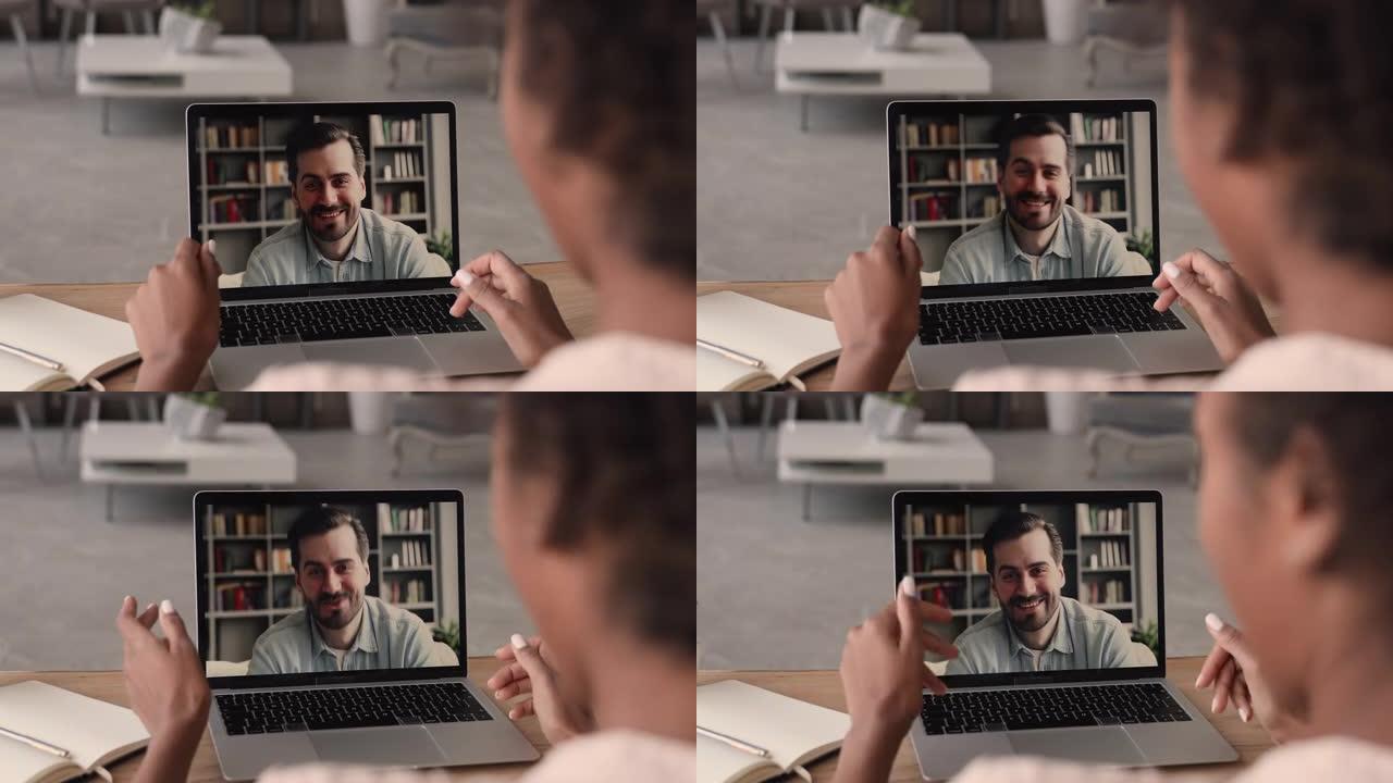 白人男子通过视频会议使用笔记本电脑与非洲妇女交谈